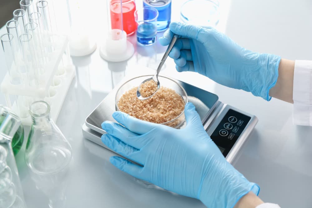 Análisis de humedad en alimentos: errores frecuentes y cómo evitarlos 1 scientist weighing petri dish with sample on scale 2026 01 11 10 50 20 utc 1